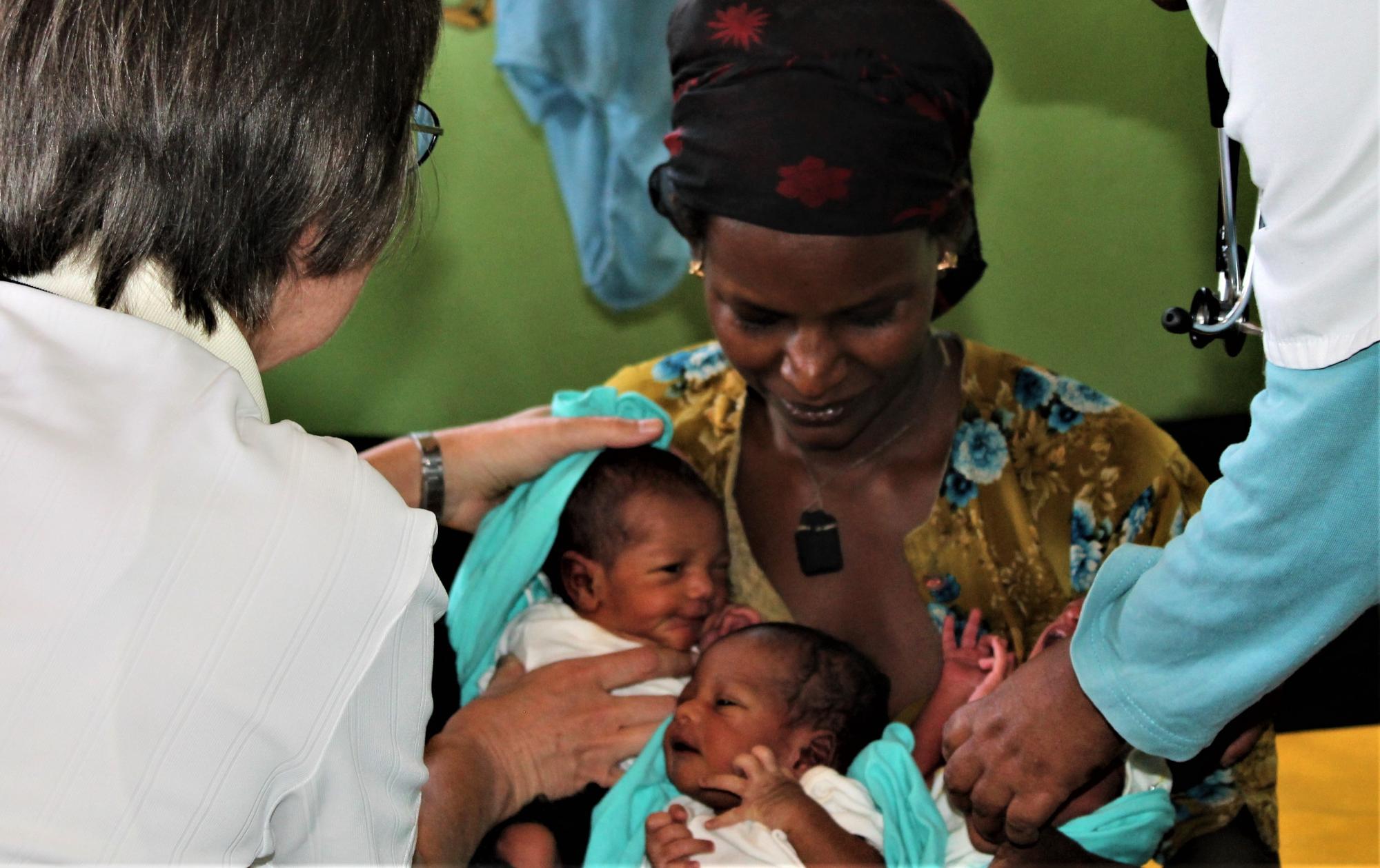 Sister Rita attends to a mother and her newborn triplets